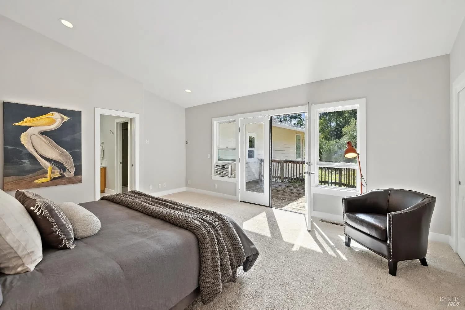 Guest bedroom with doors opening to a private deck